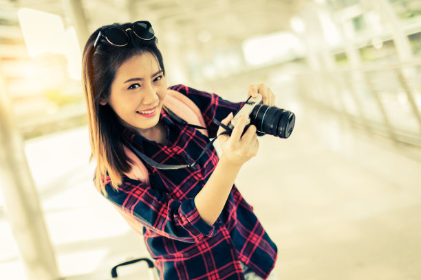 美丽幸福年轻的亚洲女孩在休闲服装独自旅行在火车站或机场与背包复古色调照片概念图片下载