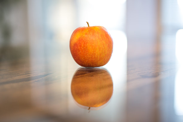 漂亮的黄红苹果放在玻璃桌上图片下载