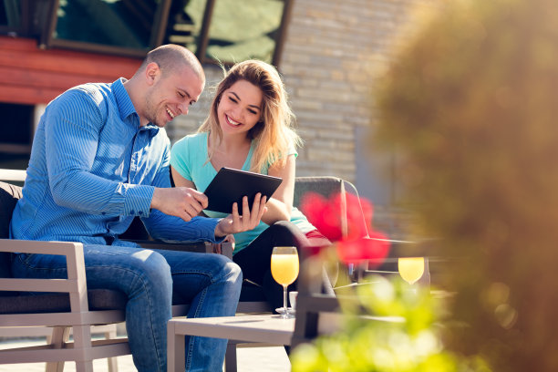 年轻夫妇，女人和男人，在街头咖啡馆喝咖啡和果汁，同时看假期的图片图片下载