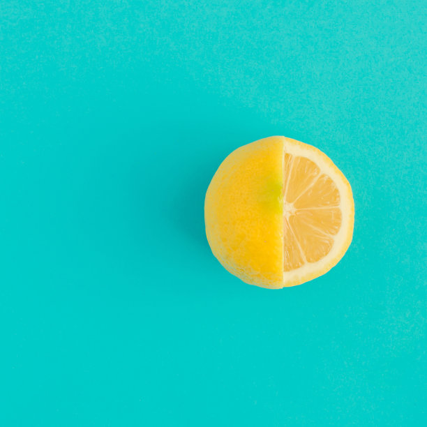 明亮蓝色背景上的黄色柠檬，简约扁平风图片下载