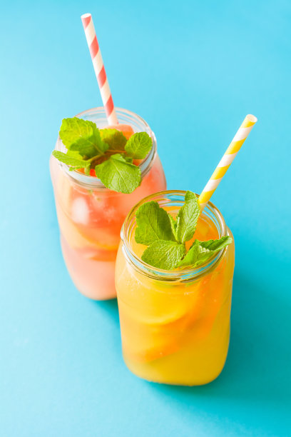 装橙汁和葡萄柚汁的瓶子，装饰冰块和薄荷图片下载