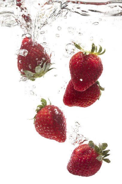 一颗新鲜的草莓被丢入水中。图片下载