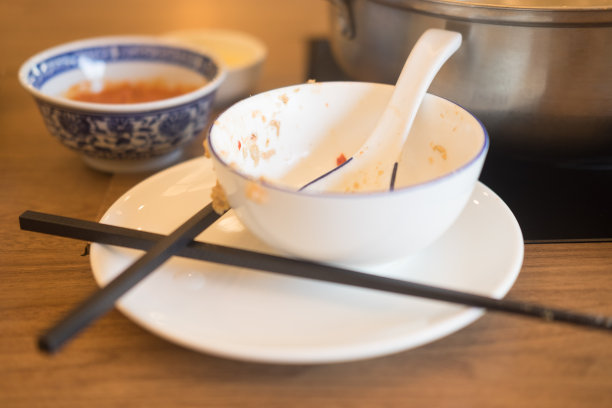在餐桌上吃完饭后用勺子的白色脏碗图片下载