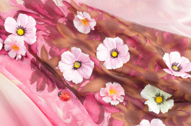 粉红色的织物镶嵌鲜花。纹理图片下载