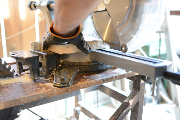 木匠的手使用圆锯的特写图片下载