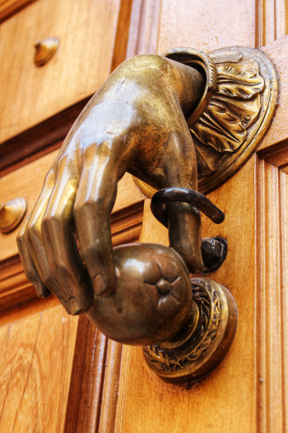 旧木门上的金色手形门环图片下载