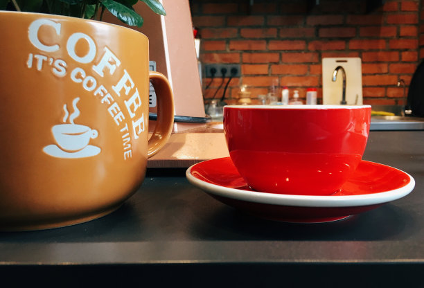 红杯咖啡，厨房桌子上有一个花盆，上面有一朵花图片下载