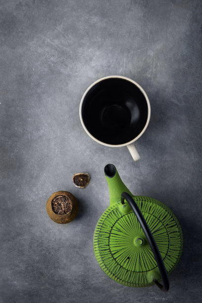 柑橘皮里发酵的陈年普洱茶，深色石材背景上的绿色水壶空杯。中国日式亚洲美食。健康饮品排毒抗氧化概念。带复制空间的简约平面素材图片