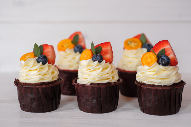 漂亮的自制草莓纸杯蛋糕放在白色的桌子上图片下载