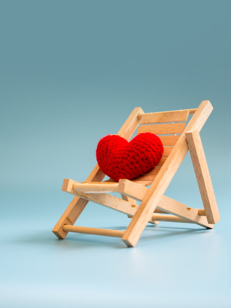 纱线红心上的木制沙滩椅上的蓝屏背景(孤立)。为文本复制空间。情人节，爱情概念和爱情背景图片下载