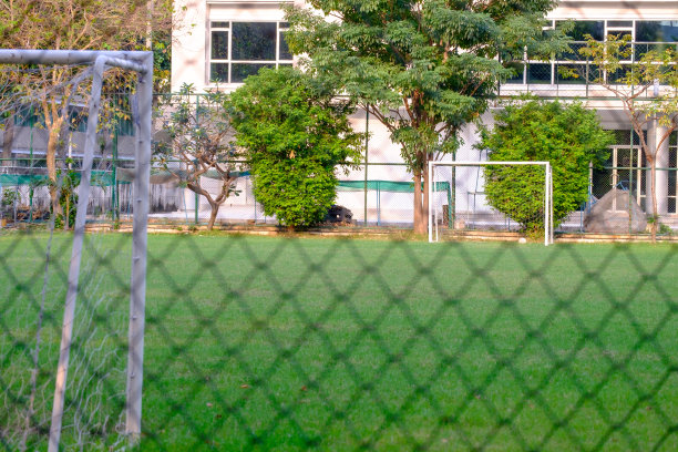 从铁丝网周围可以看到球门和足球场图片下载