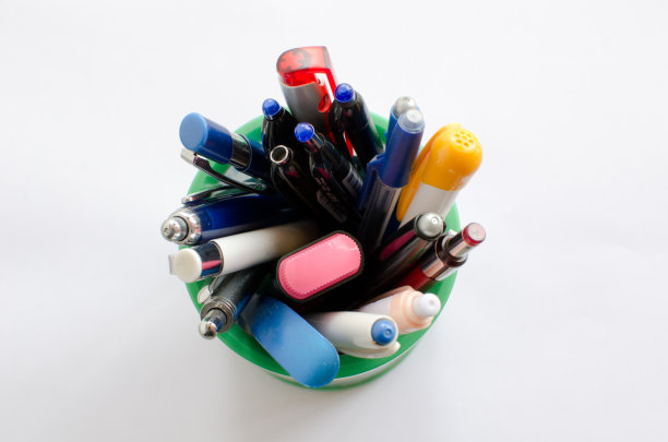 白色背景的笔筒里有很多彩色笔，图片下载