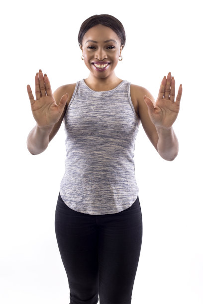 黑人女性健身教练在白色背景与停止手势素材图片