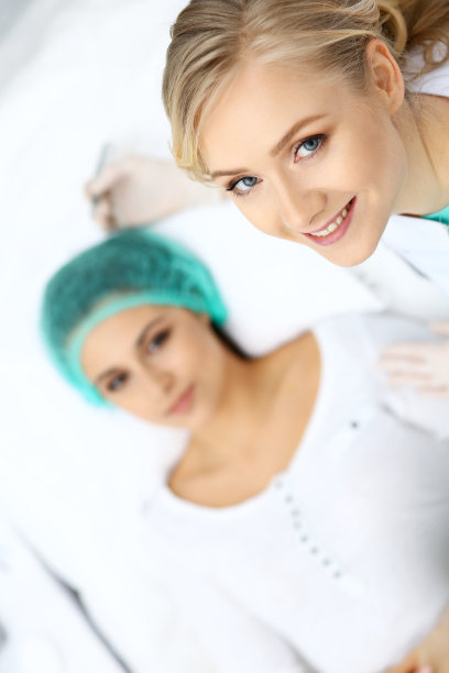 专业美容师在女人脸上纹眉。美容院永久眉妆，特写。美容应用素材图片