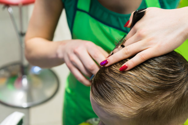 理发师给孩子理发。发型特写。图片下载
