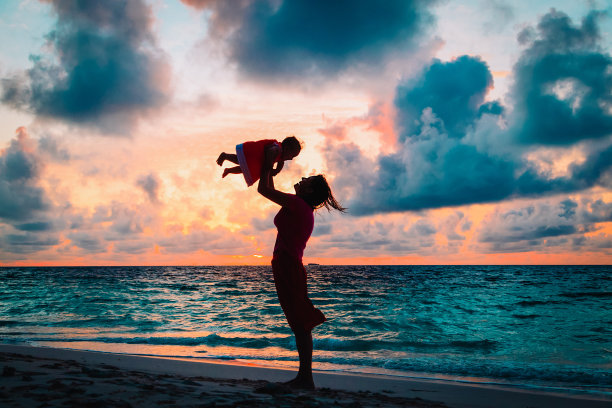 妈妈和小女儿在日落海滩上玩耍图片下载