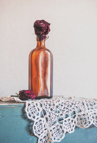 静物与干红玫瑰玻璃瓶在复古花边和旧木头图片下载