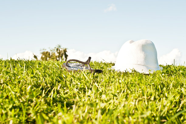 草地上的白帽子和拖鞋图片下载