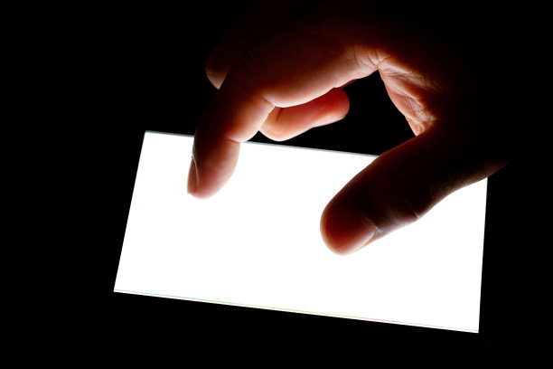 现代智能手机的手触屏在黑暗的背景下图片下载