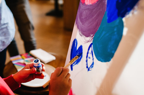 艺术家手拿毛笔和颜料，在画架上作画，在工作室作画。颜色绘画,图片。Ð树立艺术、创意、人的观念。图片下载