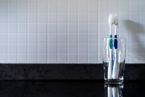 水池旁边的玻璃里有两颗蛀牙。在浴室里。图片下载