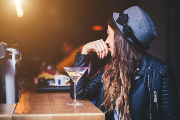 一个年轻女子坐在酒吧里图片下载