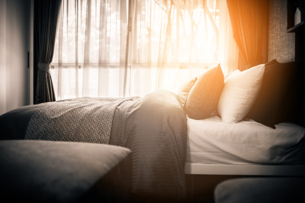 美容室的床上堆满了干净的白色枕头和床单。特写镜头。阳光下的镜头。图片下载