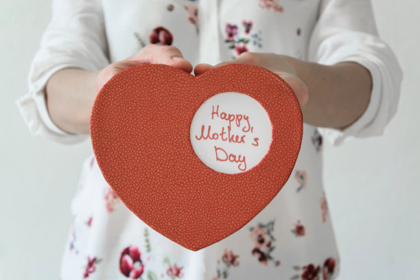 正面的妇女手捧心盒母亲节礼物。感恩现在的概念图片下载