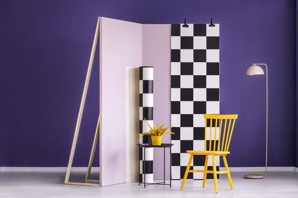 黄色的椅子和植物靠着淡粉色的墙壁和格子织物在紫罗兰色的室内。真实的照片图片下载