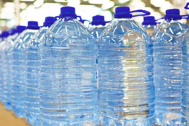 一排排清爽的天然矿泉水装在一个塑料瓶里，映衬着商店的灯笼。图片下载