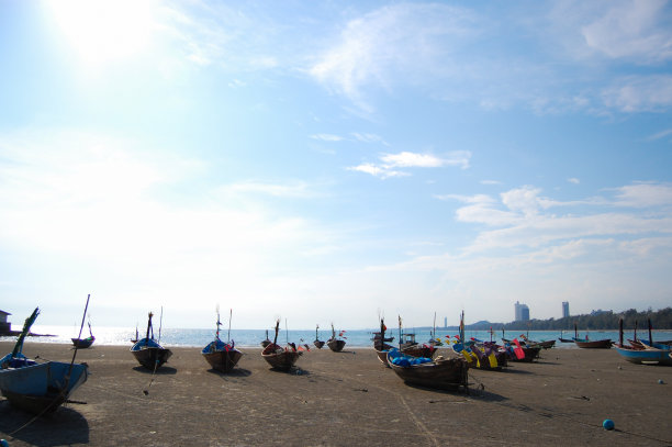 海滩上的渔船，蓝天为背景。图片下载