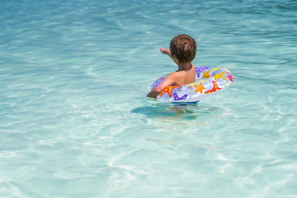 小男孩在海里的游泳管指着什么东西的背影。图片下载