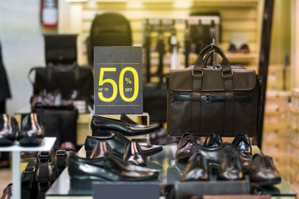 销售50%折扣模拟广告展示架设置在男鞋货架在购物商场，商业时尚和广告概念图片下载