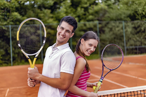 一对年轻夫妇在网球场上图片下载