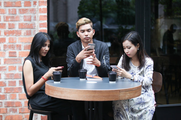 一群正在看智能手机的马来西亚年轻人图片下载