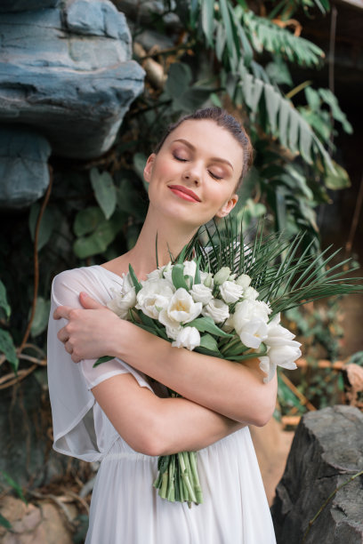 幸福美丽的新娘摆着婚礼花束素材图片