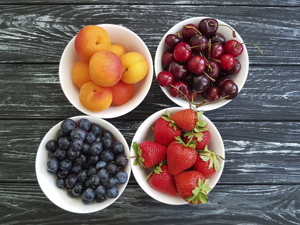 黑木板上的樱桃、杏、蓝莓和草莓图片下载