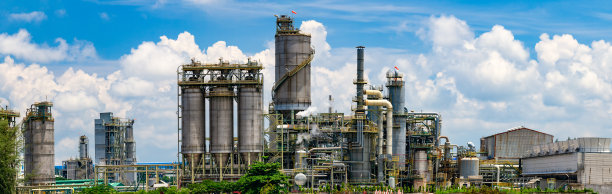 炼油厂后面是一排排的树和蓝天图片下载