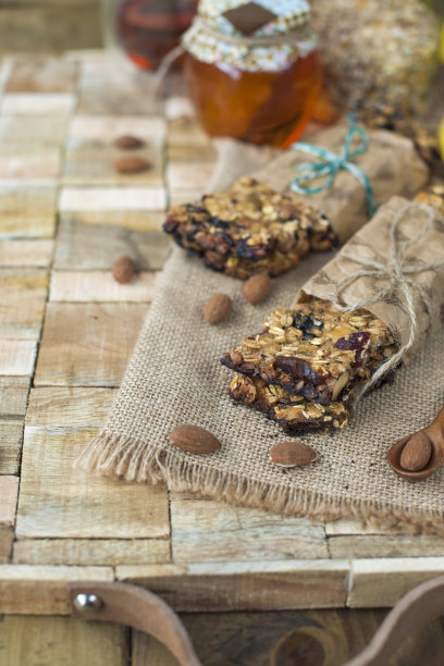 坚果，蜂蜜，装在罐子里，还有一根香蕉放在靠近眼睛的木桌上。健康的早餐。复古的照片。图片下载