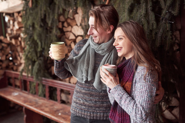 照片的快乐的男人和漂亮的女人与杯子在室外冬天。寒假放假了。圣诞快乐的一对男女喝热饮。夫妇在爱图片下载