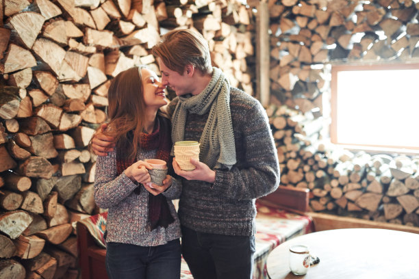照片的快乐的男人和漂亮的女人与杯子在室外冬天。寒假放假了。圣诞快乐的一对男女喝热饮。夫妇在爱图片下载