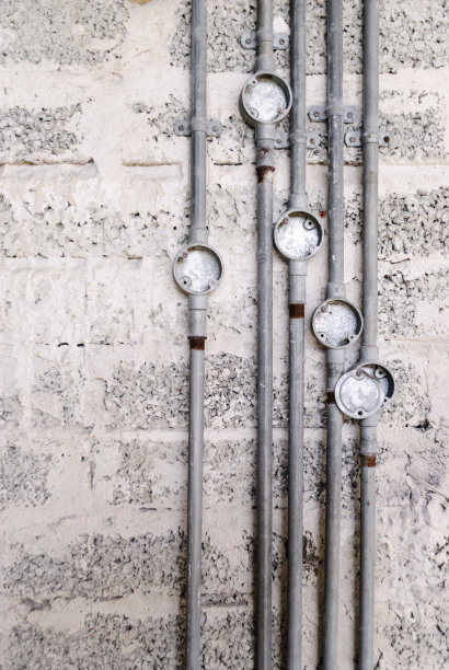 在建筑工地的一堵裸露的防风墙上的金属电线导管。图片下载