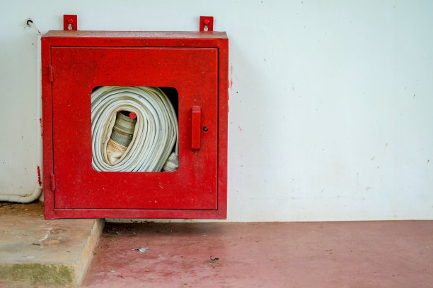 软管卷轴在墙上的背景。图片下载