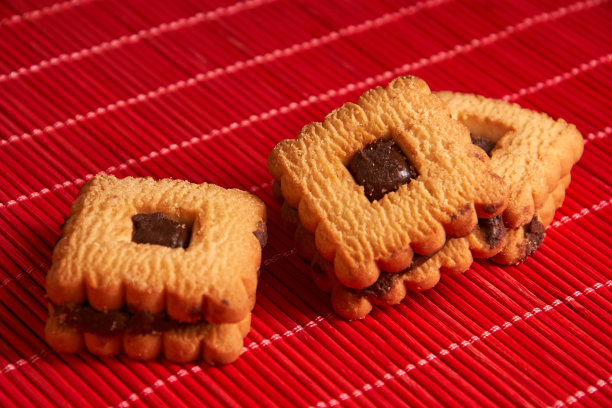 温暖的自制姜饼在红色的背景上点缀巧克力图片下载