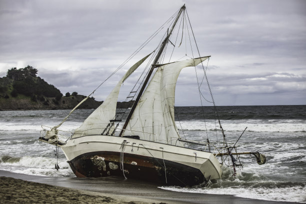 海滩上被冲上岸的帆船图片下载