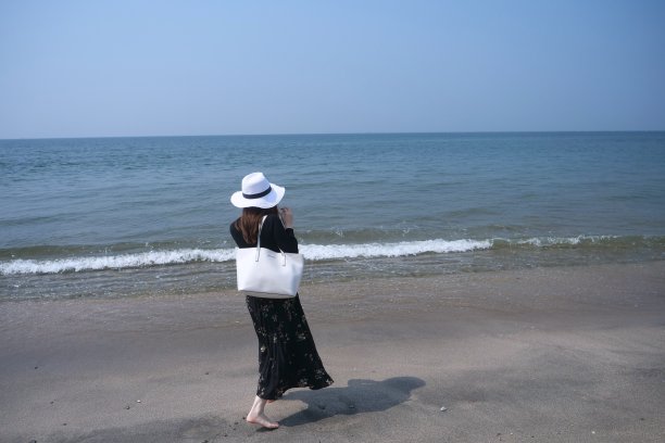 女孩走在潮湿的沙滩上图片下载