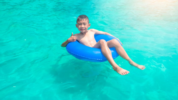 暑假在游泳池里游泳的男孩图片下载