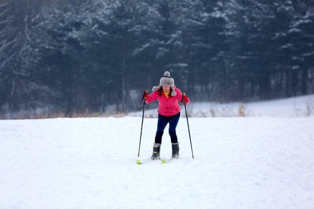 女滑雪者在雪山上滑雪图片下载