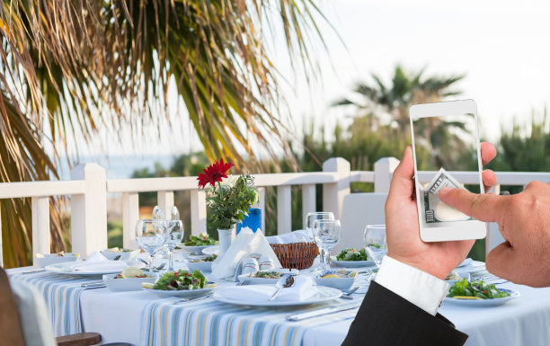 准备餐桌商人使用智能手机在线支付图片下载