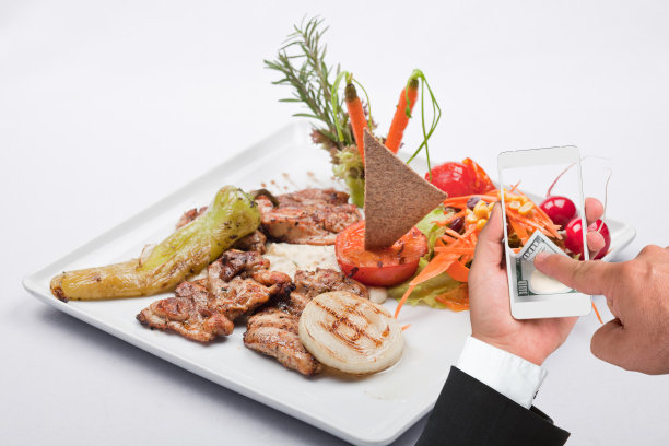烤牛排和商人使用智能手机在线支付图片下载